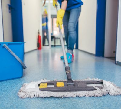 Close-up of cleaners moping the floor of a hall
